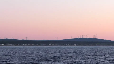 Wind turbines with the river in the foreground at sunset time Stock Footage 130862647