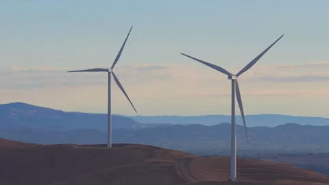 Wind Turbines On Rolling Dry Hills With Mountain Range Stock Footage 345289748