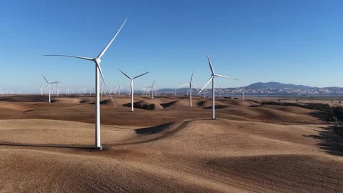 Wind Turbines On Rolling Hills In Dry Field Under Clear Blue Sky Stock Footage 344945825