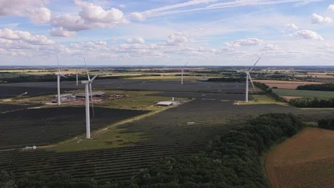 Wind Turbines Rotate Above Large Solar Panel Fields in a Rural Landscape During Stock Footage 341838102