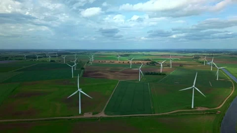 Wind turbines rotating across vast green fields under cloudy sky Stock-Footage 341328094
