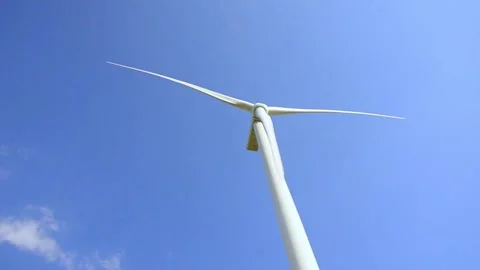 Wind turbines rotating in a green field under blue sky 스톡 동영상 339094854