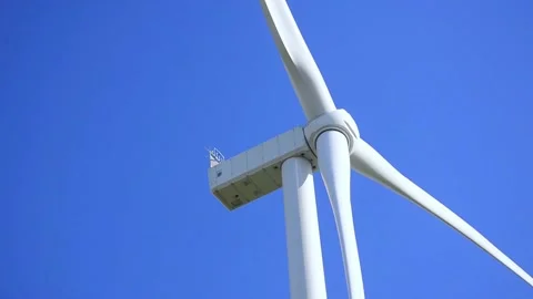 Wind turbines rotating in a green field under blue sky 스톡 동영상 339094882