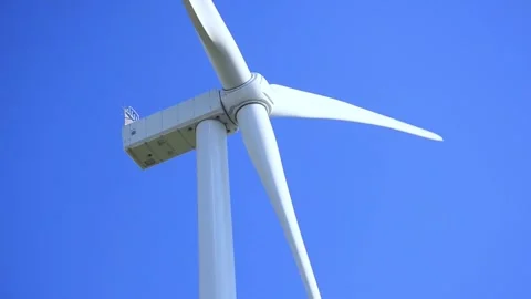Wind turbines rotating in a green field under blue sky 스톡 동영상 339094884