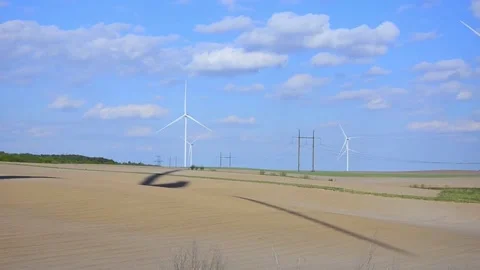 Wind turbines rotating in a green field under blue sky 스톡 동영상 339094888