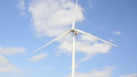 Wind turbines rotating in a green field under blue sky 스톡 동영상 339094889