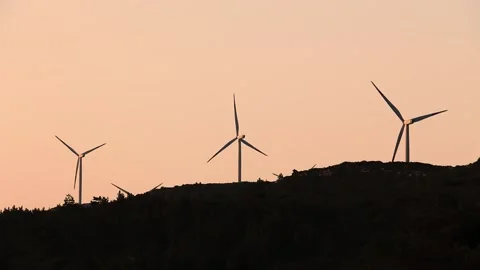 Wind turbines rotating on mountain top at sunset. Vídeo Stock 157101535