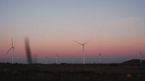 Wind turbines rotating at sundown spinning at colorful dawn Stock Footage 170724153