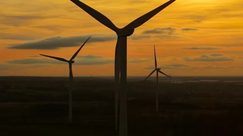 Wind turbines rotating under vibrant sunset producing renewable electricity Stock Footage 309640649