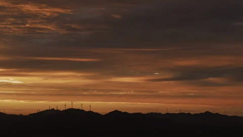Wind Turbines Silhouette Mountain Dramatic Golden Hour Tracking Left 4K HLG Stock Footage 344015633