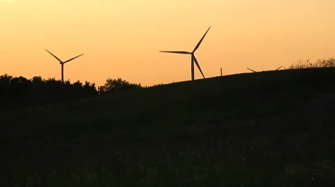 Wind Turbines Silhouetted Against Deep Orange Sky Stock Footage 7745887
