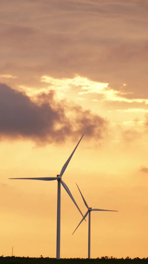 Wind Turbines Silhouetted Against a Dramatic Orange Sunset Sky Stock Footage 296931014