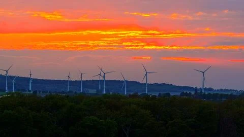 Wind Turbines Silhouetted at Dramatic Orange Sunset Stock Photos