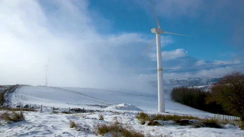 Wind turbines in the snow on welsh mountains south wales uk. cloud passing over 스톡 동영상 148484199