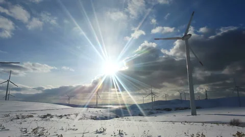 Wind Turbines, Snowfields, and the Rays of the Setting Sun Video stock 324967650