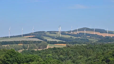 Wind Turbines Span Rolling Hills Across Lush Rural Landscape Under Clear Blue Stock Footage 346261704