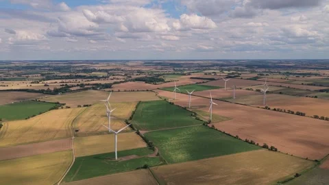 Wind Turbines Spin in the Afternoon Light Over the Flat Agricultural Fields of Stock Footage 341838227
