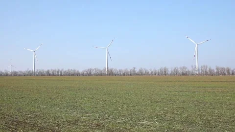 Wind turbines spin energetically against a blue sky, harnessing renewable energy Stock Footage 304462827