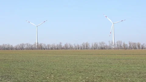 Wind turbines spin energetically against a blue sky, harnessing renewable energy Stock Footage 304462995