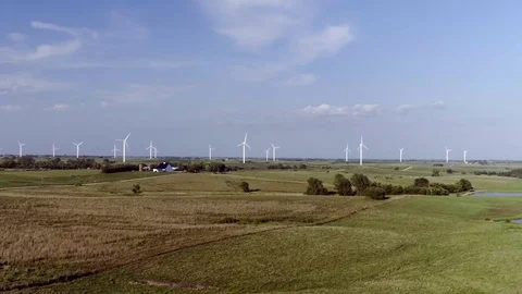 Wind Turbines Spin in Field Behind Farm Stock Footage 75873881