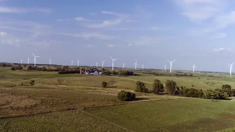 Wind Turbines Spin in Field Behind Farm Stock Footage 75934911