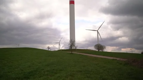 Wind turbines spin on the hill as dark clouds move across the sky Stock Footage 164608353