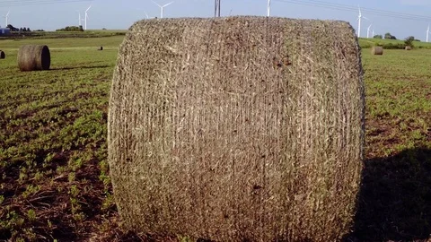 Wind Turbines Spin Over Field of Hay Bales Stock Footage 75934913