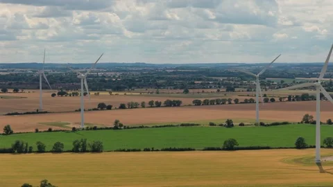 Wind Turbines Spin Slowly Above Golden Wheat Fields in the English Countryside Stock Footage 341838130