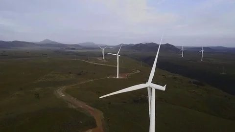 Wind turbines spinning with mountains in background Stock Footage 71615095