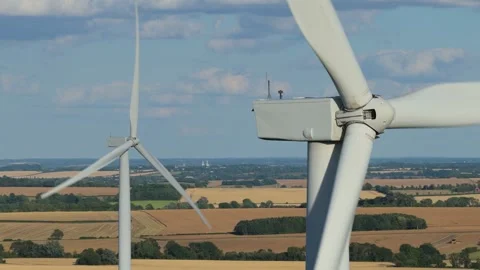 Wind Turbines Spinning in Open Fields Under Blue Sky During a Sunny Summer Stock Footage 341838235