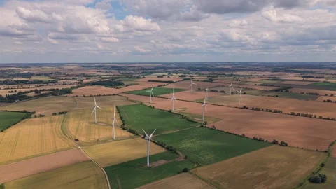 Wind Turbines Spinning Over Large Agricultural Fields on a Sunny Summer Stock Footage 341838209