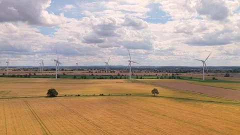 Wind Turbines Spinning Over the Wheat Fields in the Countryside During a Summer Stock Footage 342771191