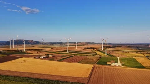 Wind turbines stand in fields during daylight hours in an open area Stock Footage 343122771