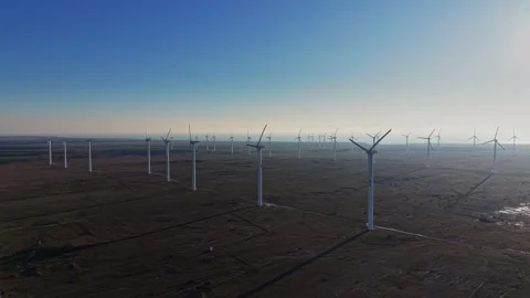 Wind turbines standing tall in vast open field during clear day Stockbeeldmateriaal 336541679