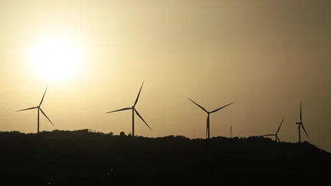 Wind turbines at sunset on a hill Stock Footage 161838595