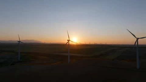 Wind turbines at sunset over fields Stock Footage 300617418