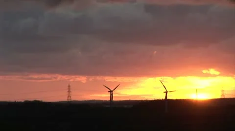 Wind turbines in sunset with pylon in background Video stock 12502938