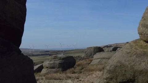 Wind turbines through gap between stones Vídeo Stock 75335285