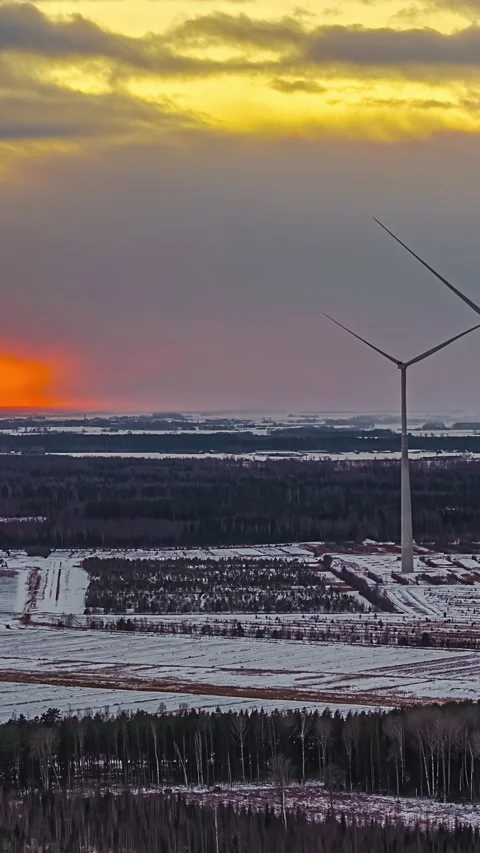 Wind Turbines Towering Over Snow Covered Fields at Sunset Stock Footage 337649225