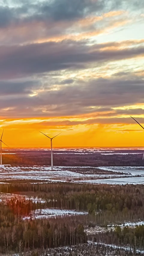 Wind Turbines Turning Over Snowy Forest at Sunset in Winter Timelapse Scene Stock Footage 341706347