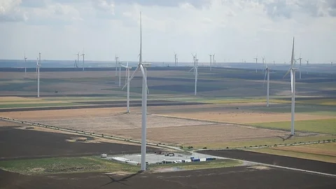 Wind turbines in a wind farm with a dramatic stormy sky in the background Video stock 113408174