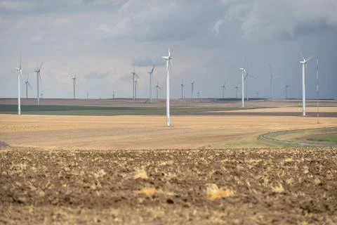 Wind turbines in a wind farm with a dramatic stormy sky in the background Stock Photos