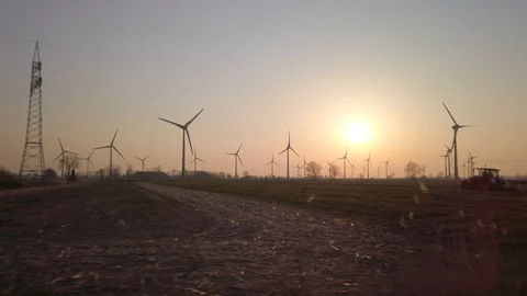 Wind turbines in windpark at sundown with tractor Video stock 128225804