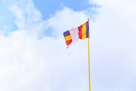 Wind Wavering colorful Buddhist flag in Buddhist temple with blank blue sky b Stock Photos