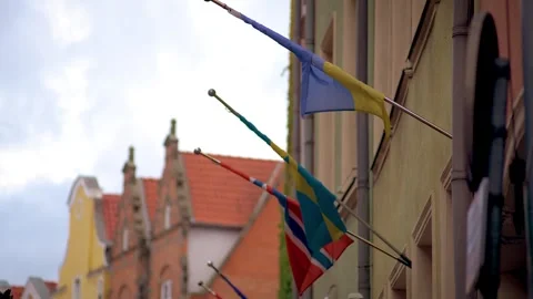 Wind wrapped flags on flagpoles. Flags of Ukraine and Great Britain in Polish Stock Footage 253273543