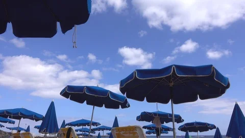 Windblown blue parasols on the beach at Playa Dorada. Stock Footage 112671745