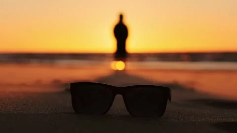 Windblown Sunglasses on Baltic Beach at Sunset as Woman Walks Through Dunes Vidéo 336665736