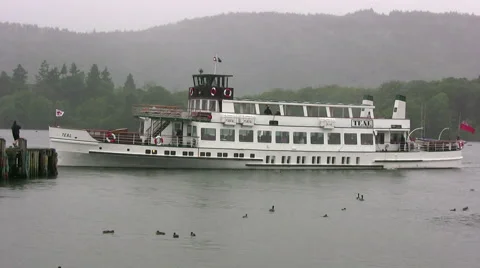 Windermere steamer MV Teal approaching Bowness pier on a grey, wet day Stock Footage 46399037