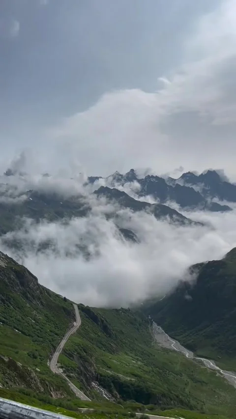 Winding Alpine Mountain Pass Road with Clouds Stock Footage 339881531