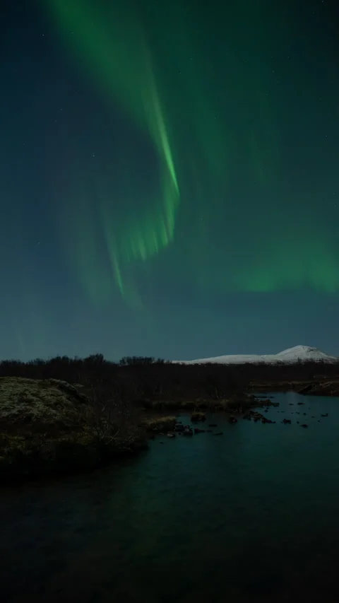 Winding aurora borealis over mountain lake Thingvellir Iceland vertical format Stock Footage 326794125